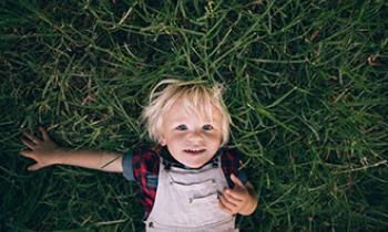 Raising Healthy Active Kids - A kid laying on grass